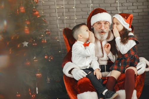 studio fotografija, djeca sjede Djedu Božićnjaku u krilu i šapuću mu svoje želje